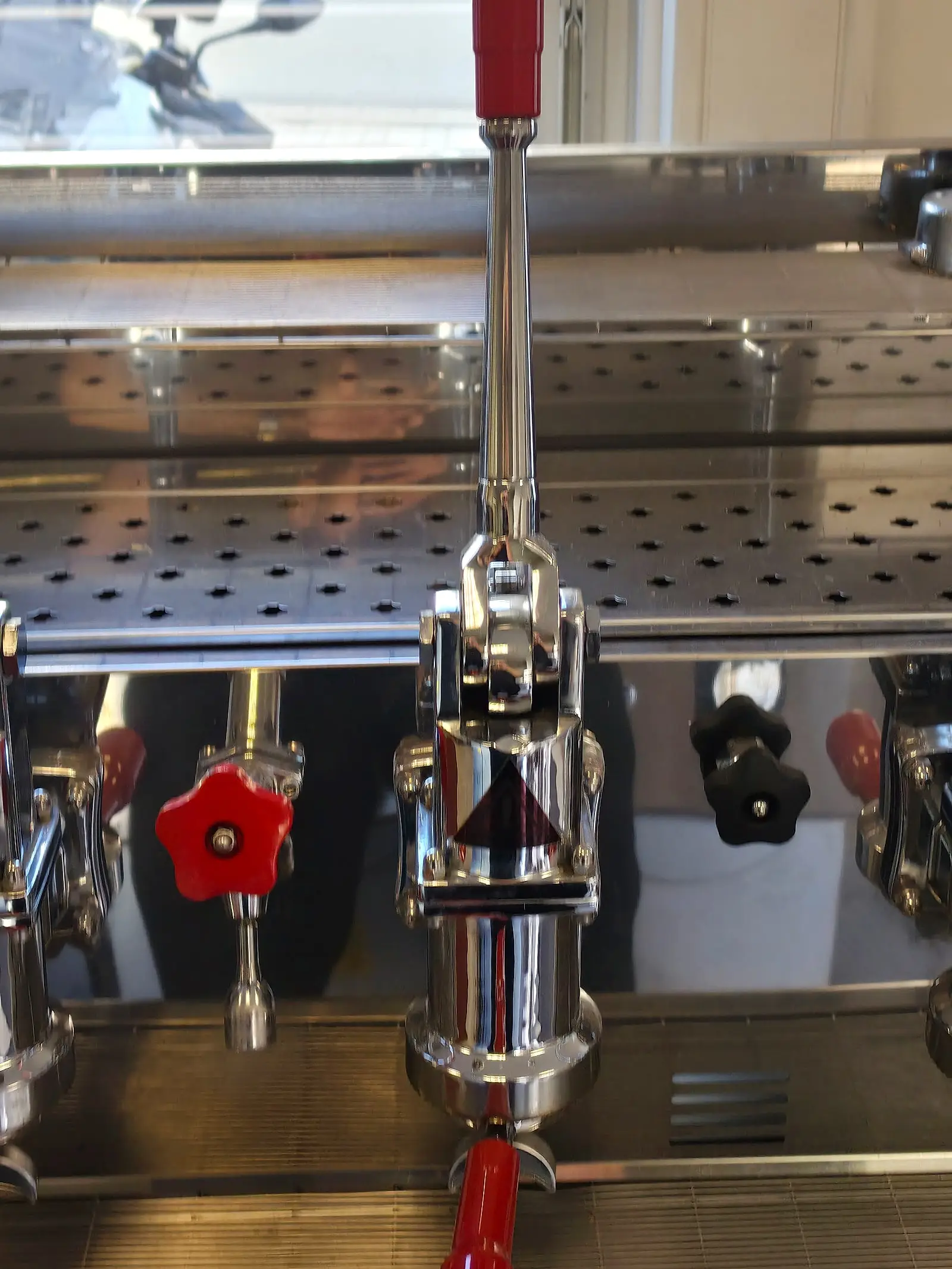 Nahaufnahme einer Brühgruppe mit Handhebel und Siebträger an einer Espressomaschine