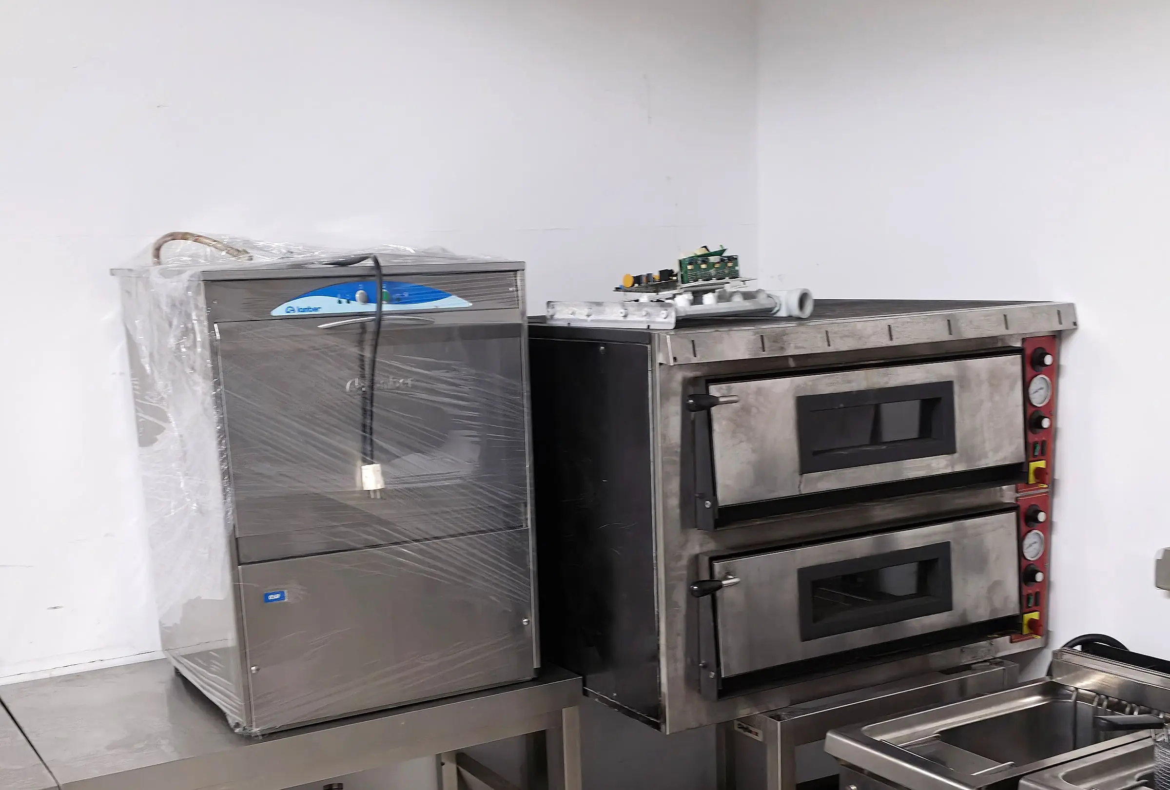 Zweikammer-Pizzaofen auf Untergestell und Teigknetmaschine im Lager