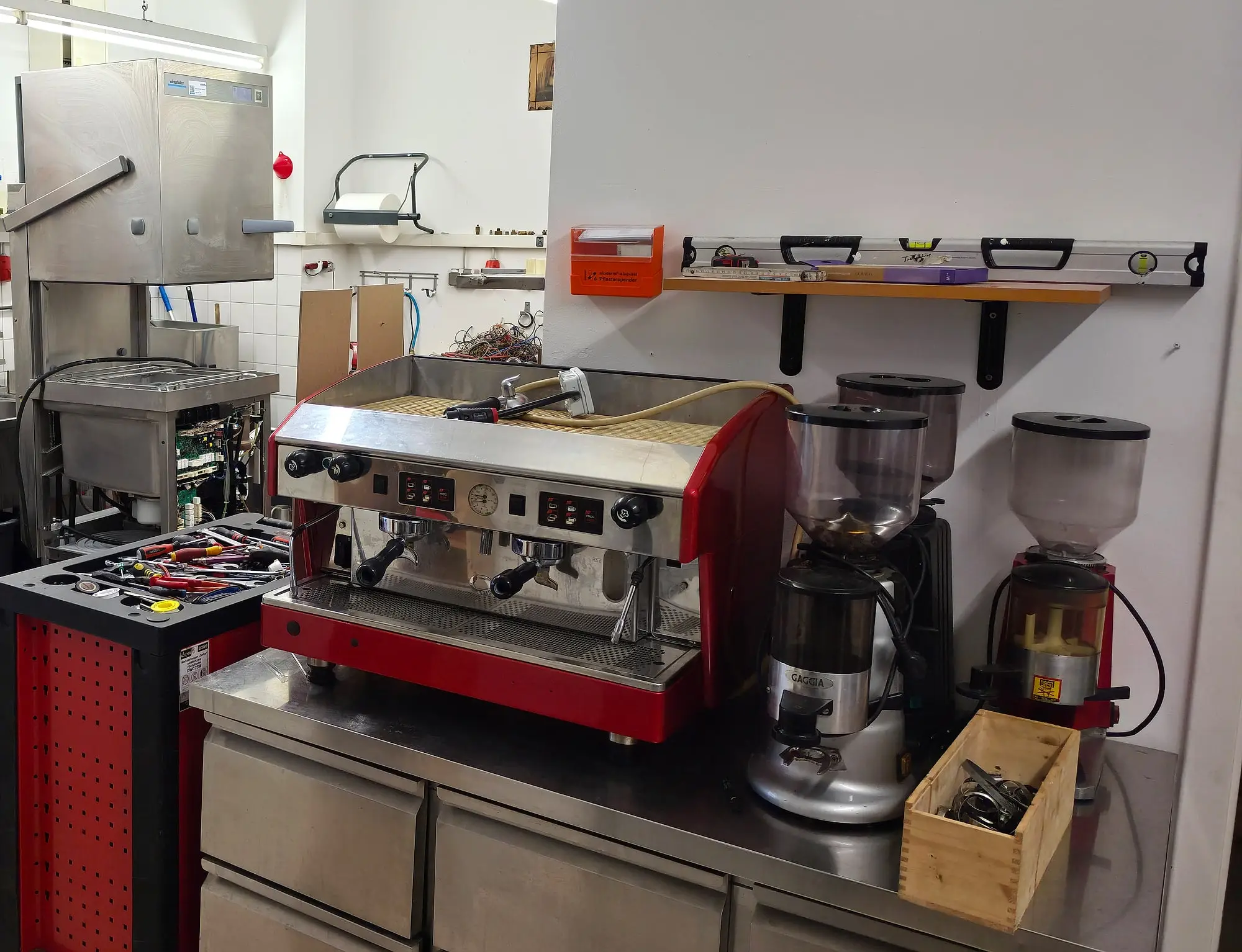 Werkstatt der Materazzi GmbH: Siebträgermaschine auf der Werkbank, Kaffeemühlen, Werkzeugwand und Werkzeugwagen
